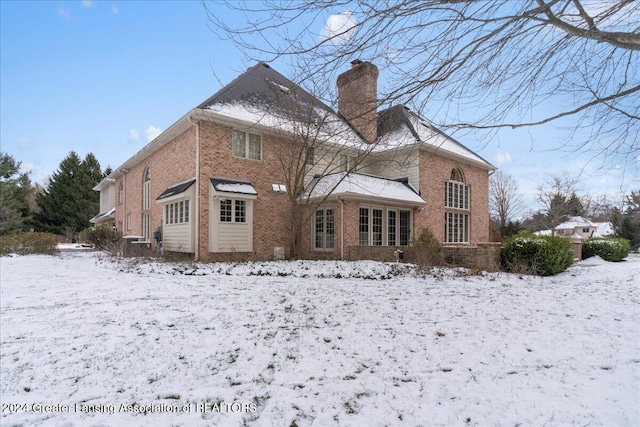 view of snow covered back of property