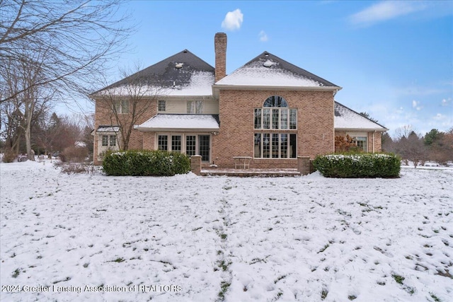 view of snow covered back of property