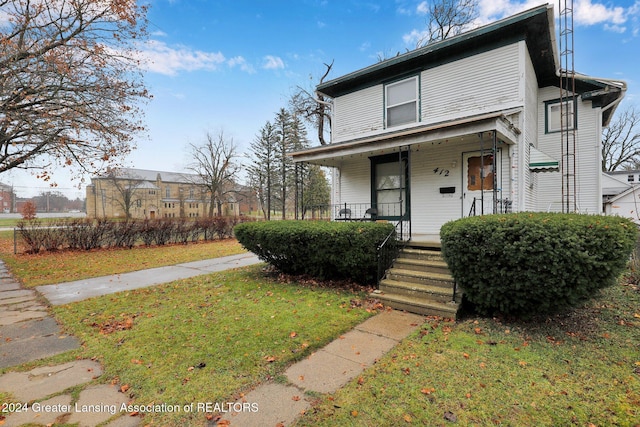 view of property featuring a porch and a front yard