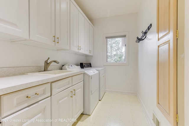 laundry room with cabinets, sink, and washer and dryer