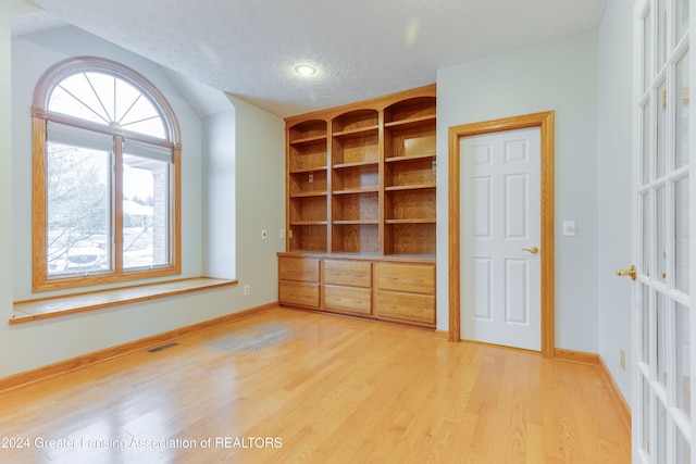 unfurnished bedroom featuring hardwood / wood-style flooring and a textured ceiling