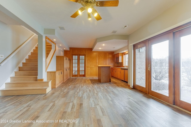 unfurnished living room with french doors, ceiling fan, and light hardwood / wood-style floors