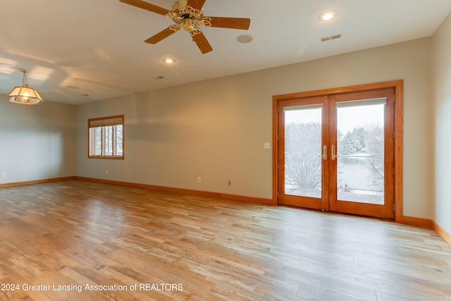 empty room featuring french doors, ceiling fan, and light hardwood / wood-style floors