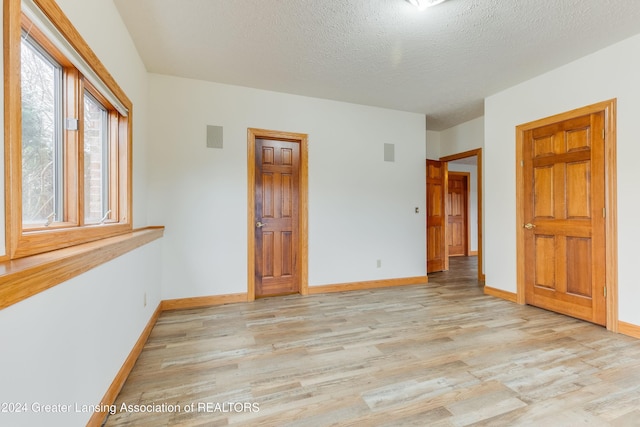 unfurnished bedroom featuring a textured ceiling and light hardwood / wood-style floors