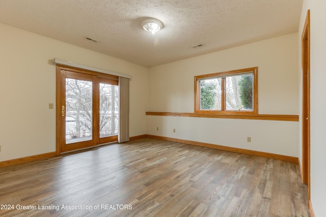 unfurnished room featuring hardwood / wood-style floors and a textured ceiling