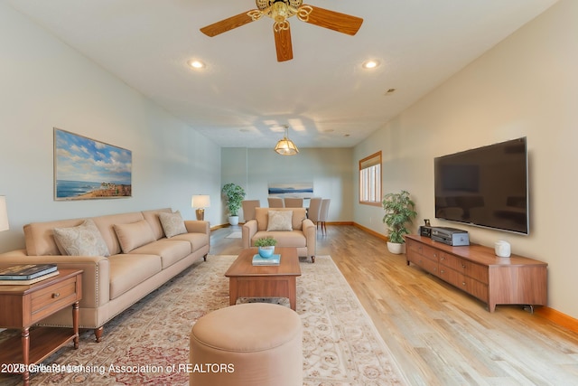 living room featuring ceiling fan and light hardwood / wood-style flooring