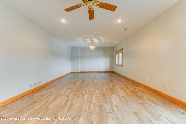 empty room with ceiling fan and light hardwood / wood-style floors