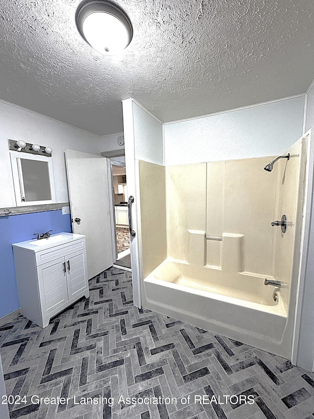 bathroom with shower / bathing tub combination, vanity, and a textured ceiling