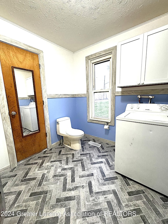 laundry room featuring hookup for a washing machine, cabinets, and a textured ceiling