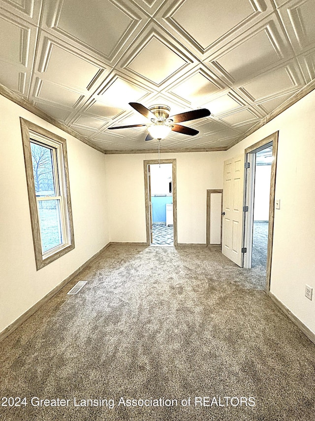 carpeted spare room featuring ceiling fan and coffered ceiling