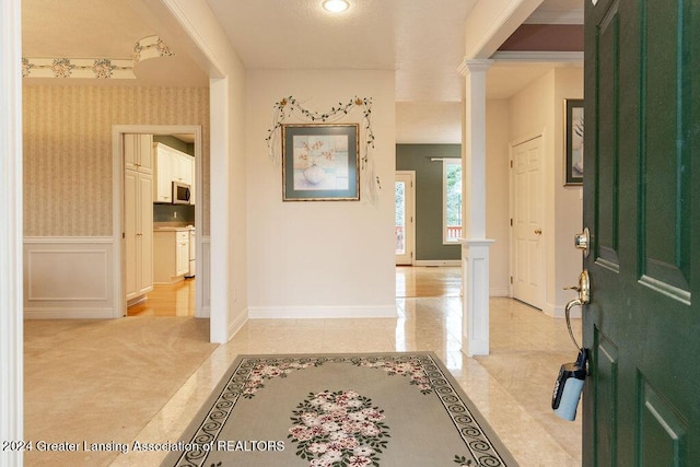 carpeted foyer entrance featuring ornate columns