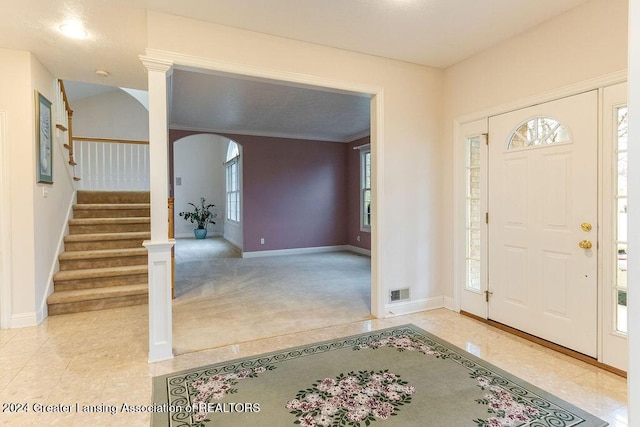 foyer entrance featuring plenty of natural light and light colored carpet