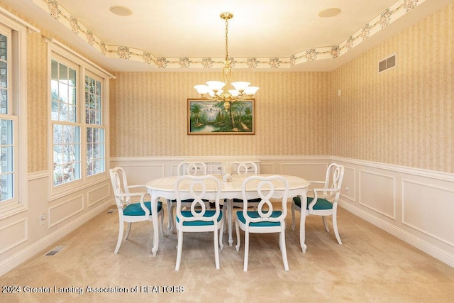 dining room featuring carpet and a notable chandelier