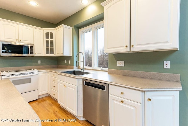 kitchen with white cabinets, sink, light wood-type flooring, and stainless steel appliances