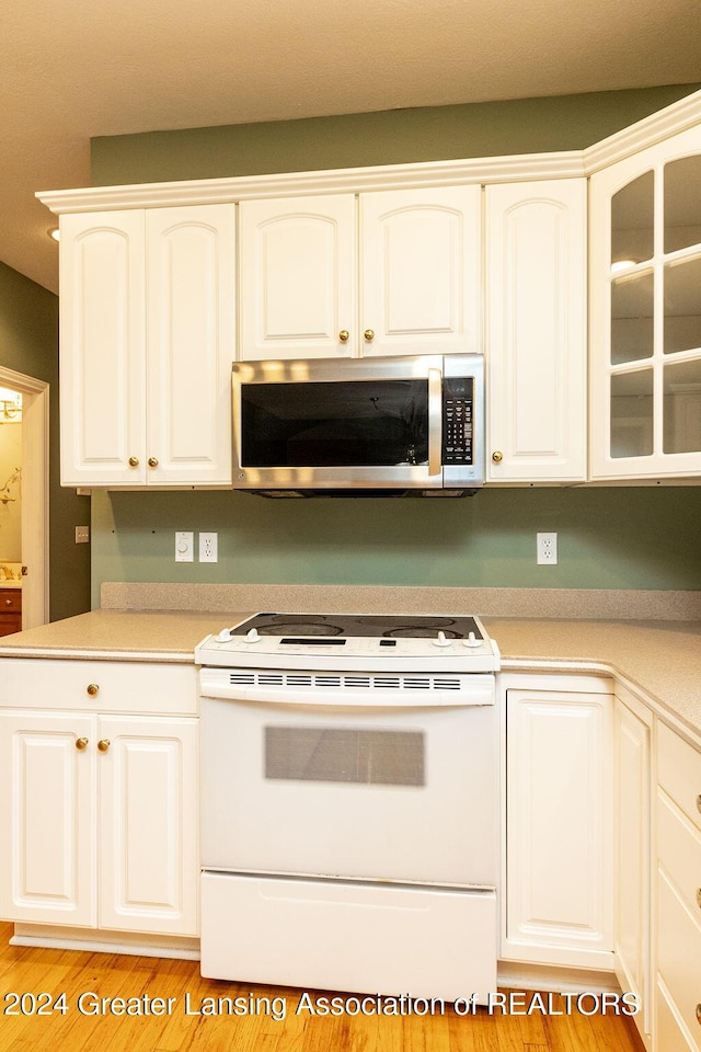 kitchen featuring white cabinets, white electric range, and light hardwood / wood-style flooring