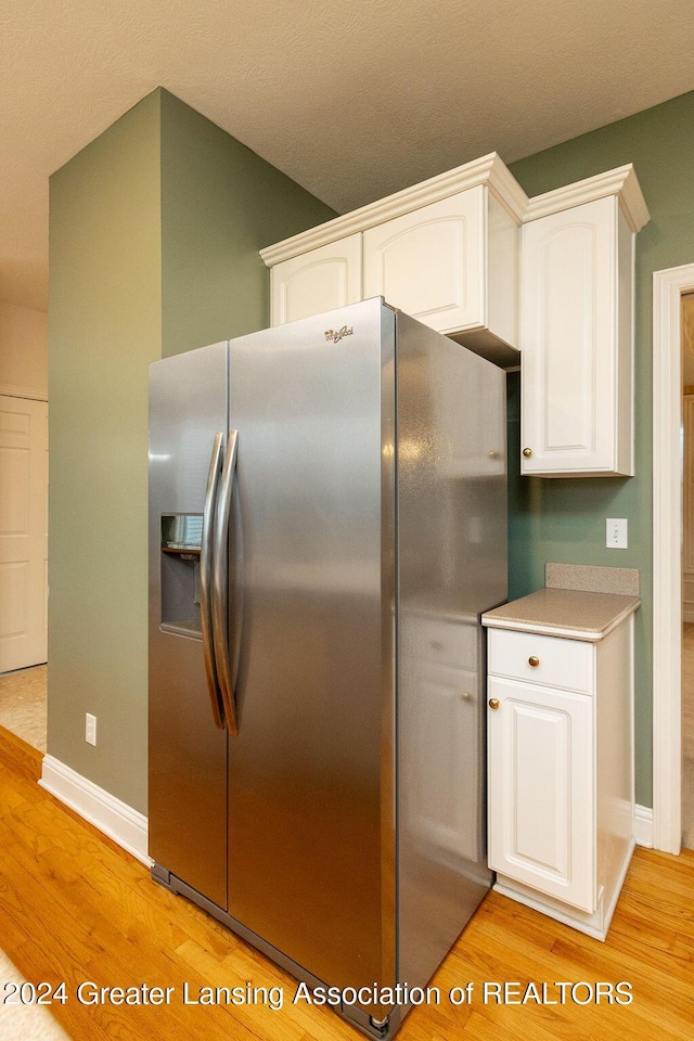 kitchen featuring white cabinets, stainless steel fridge with ice dispenser, and light hardwood / wood-style floors