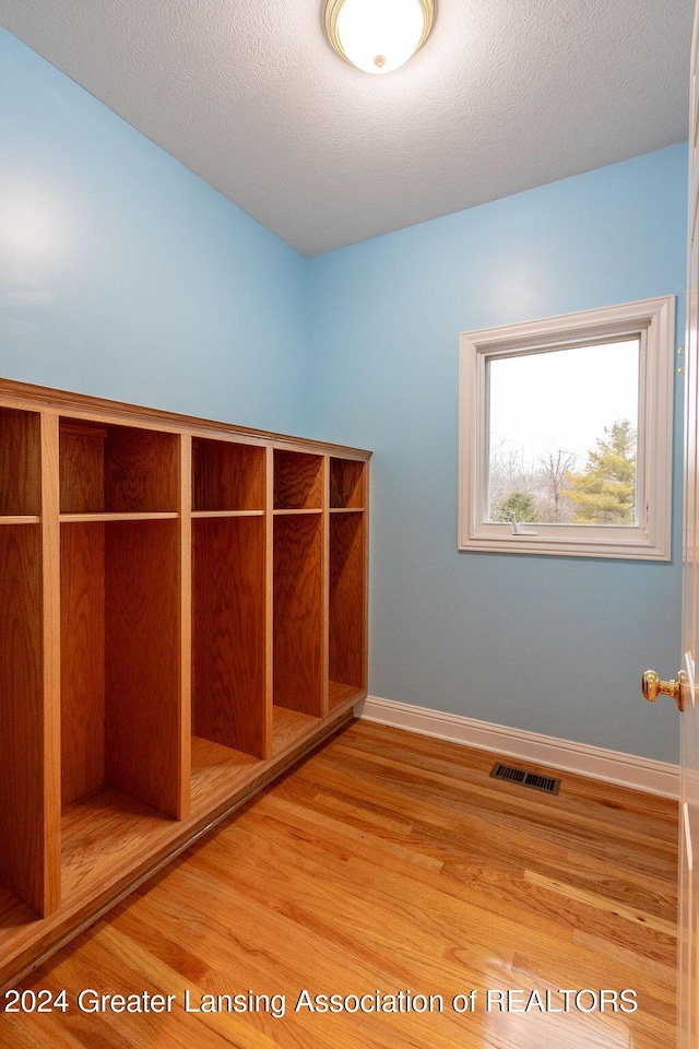 mudroom with a textured ceiling and hardwood / wood-style flooring