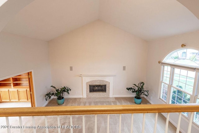 living room with a premium fireplace, wood-type flooring, and lofted ceiling