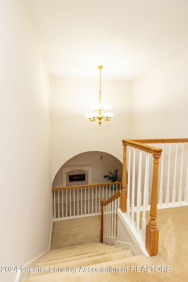 staircase with carpet and a chandelier