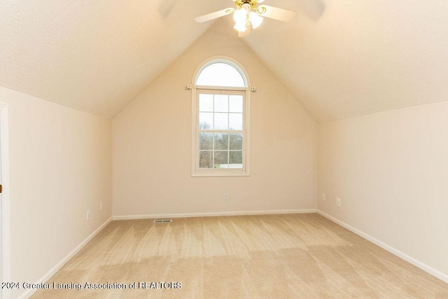 additional living space with light carpet, ceiling fan, and vaulted ceiling