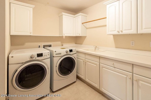 clothes washing area with cabinets, independent washer and dryer, and sink