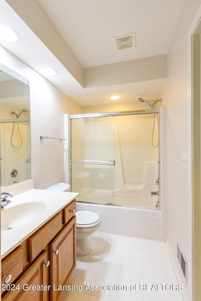 full bathroom featuring shower / bath combination with glass door, vanity, toilet, and tile patterned flooring