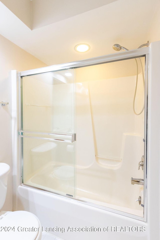 bathroom featuring shower / bath combination with glass door and toilet