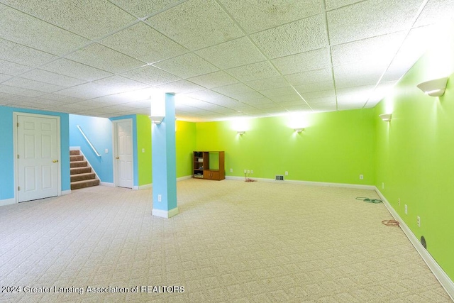 basement featuring a paneled ceiling and carpet