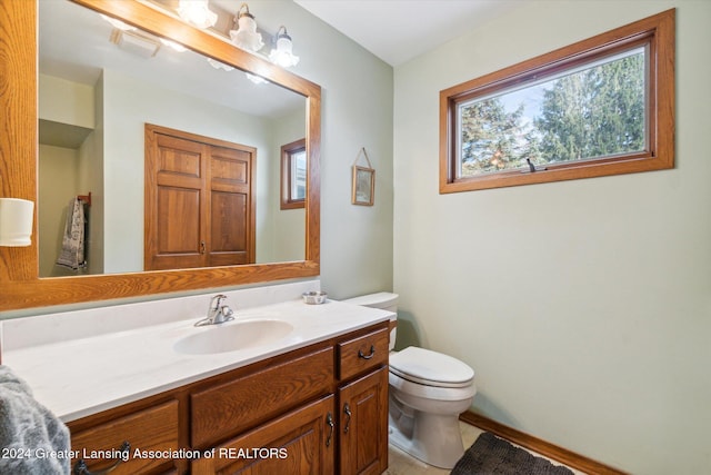 bathroom with tile patterned flooring, vanity, and toilet