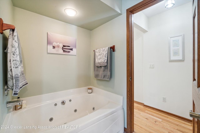 bathroom with a bath and hardwood / wood-style flooring