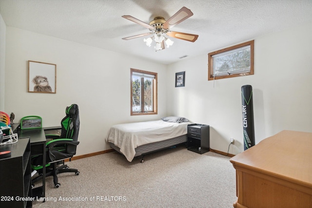 carpeted bedroom with a textured ceiling and ceiling fan