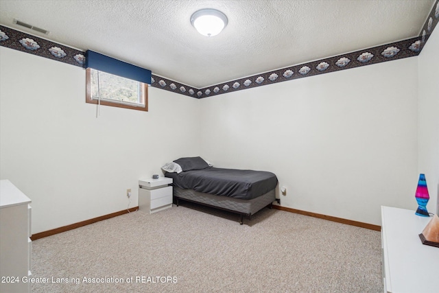 bedroom with light carpet and a textured ceiling