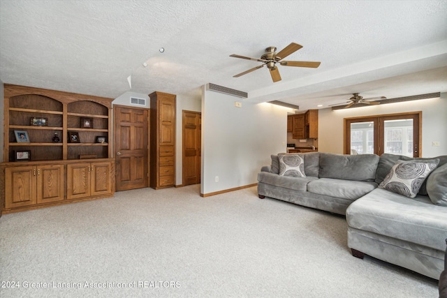 carpeted living room with a textured ceiling and ceiling fan