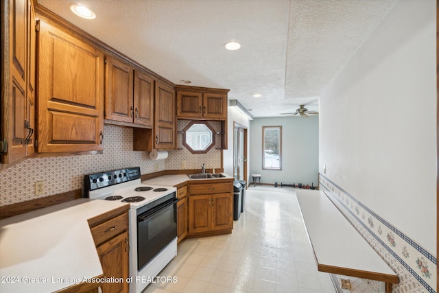 kitchen with a textured ceiling, ceiling fan, sink, and white electric stove