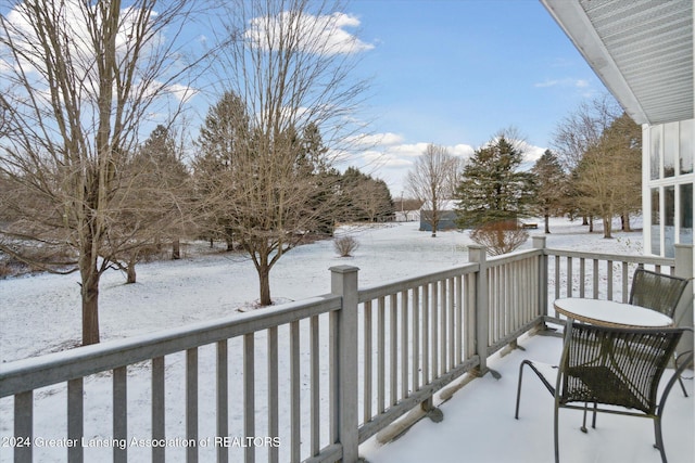 view of snow covered back of property