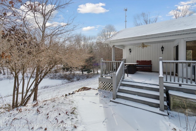 snow covered deck with ceiling fan and a porch