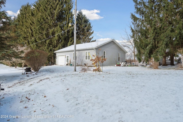 view of snowy exterior with a garage