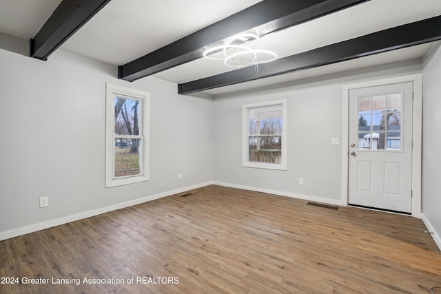 foyer featuring beam ceiling, light hardwood / wood-style flooring, and a healthy amount of sunlight