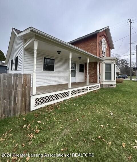 exterior space featuring covered porch and a front lawn