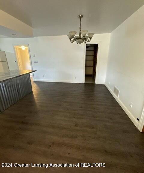 interior space with dark hardwood / wood-style floors and an inviting chandelier