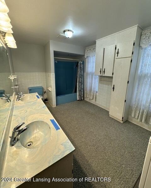 bathroom featuring vanity and tile walls