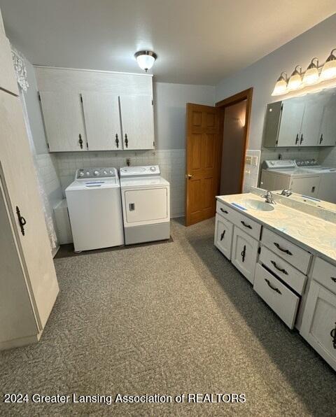 laundry room featuring cabinets, washing machine and dryer, and sink