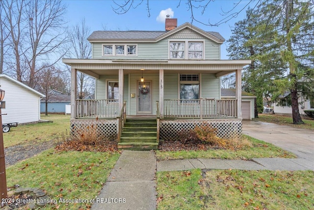 view of front facade with an outdoor structure, a front lawn, and a porch