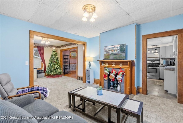 carpeted living room featuring a chandelier