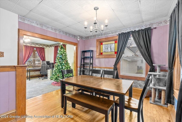 dining space with light hardwood / wood-style floors and a chandelier