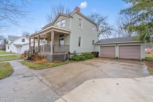 view of front of home featuring a porch, a garage, and an outdoor structure