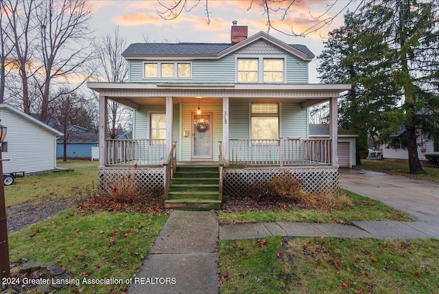 view of front facade with a lawn and covered porch