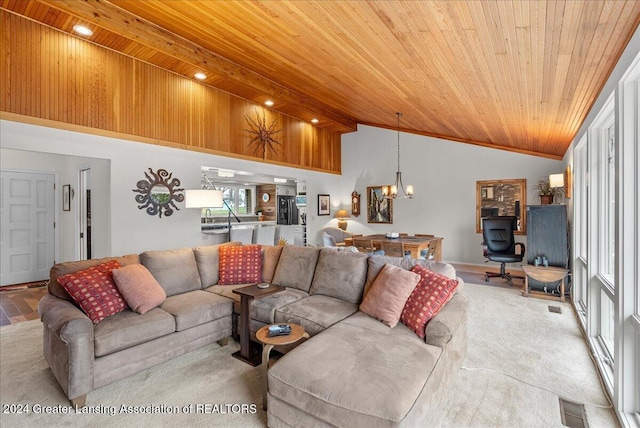 living room with vaulted ceiling with beams, light colored carpet, wood ceiling, and an inviting chandelier