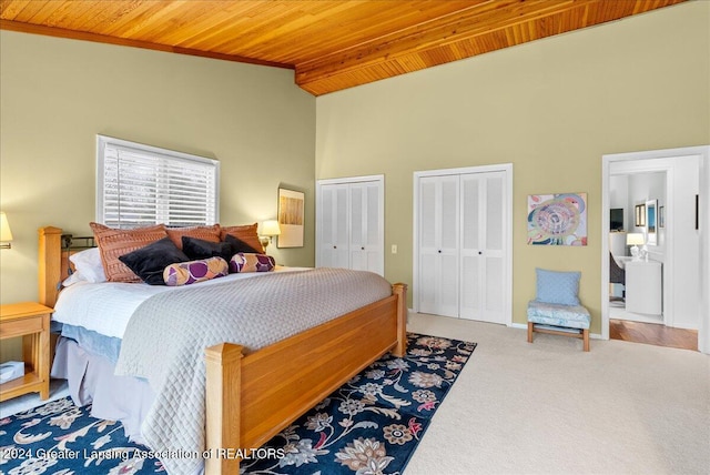 bedroom with wooden ceiling, high vaulted ceiling, carpet flooring, beamed ceiling, and multiple closets