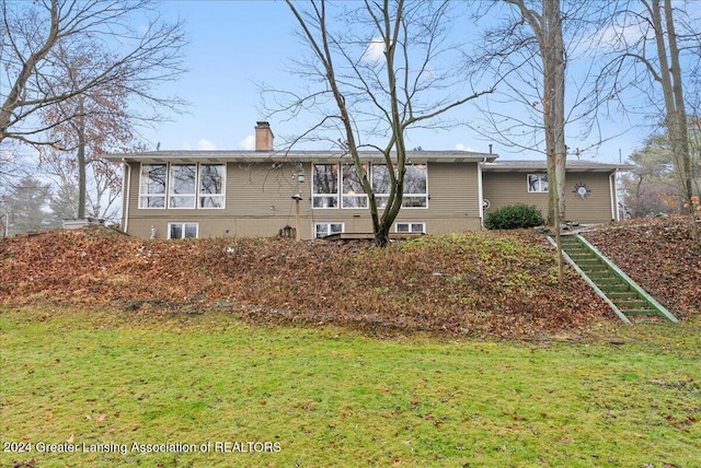 rear view of property featuring a yard